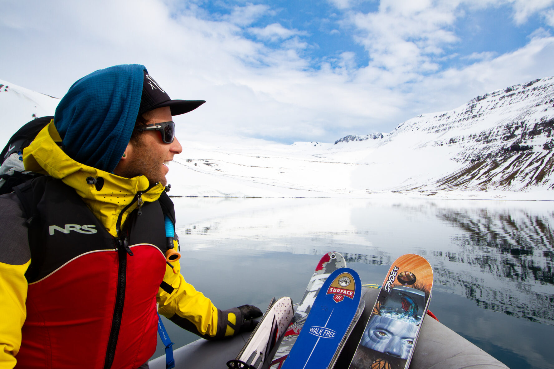 A skier looking at the horizon from his sailboat in the Westfjords.