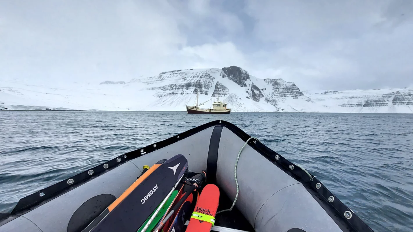 A skier heading to a sailboat in the Westfjords, Iceland.