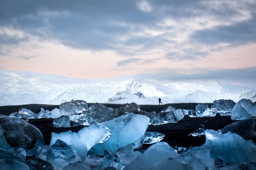 A hiker stands on Iceland’s mystical Diamond Beach.