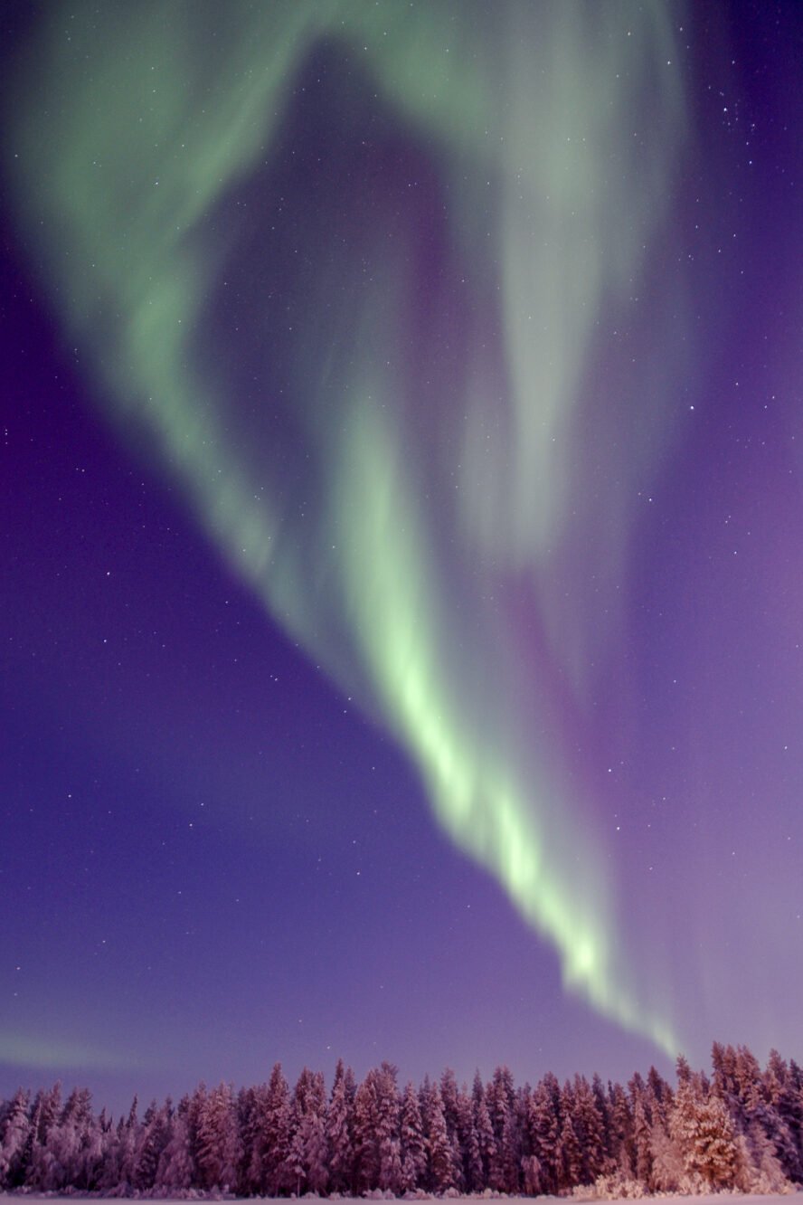 Wispy green aurora in a human figure over Lapland.