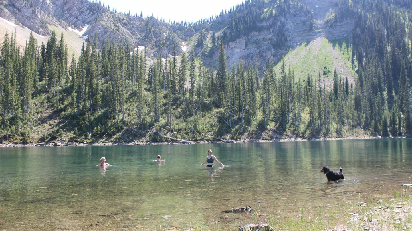 All-women backpacking. swimming in lake, Montana