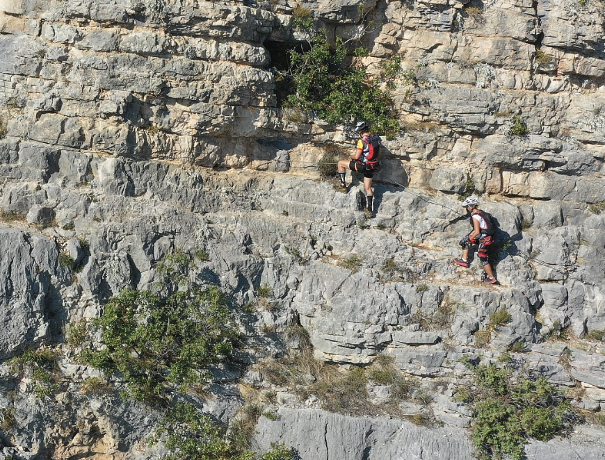 Two people scrambling along the via ferrata on Cikola river