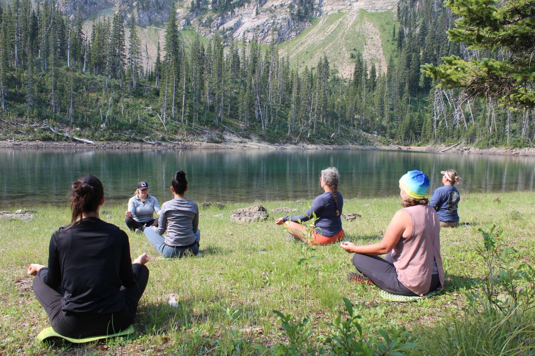 Group meditating near a lake in Whitefish, Montana