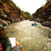 Kayakers in inflatable rafts paddle down the Rogue River