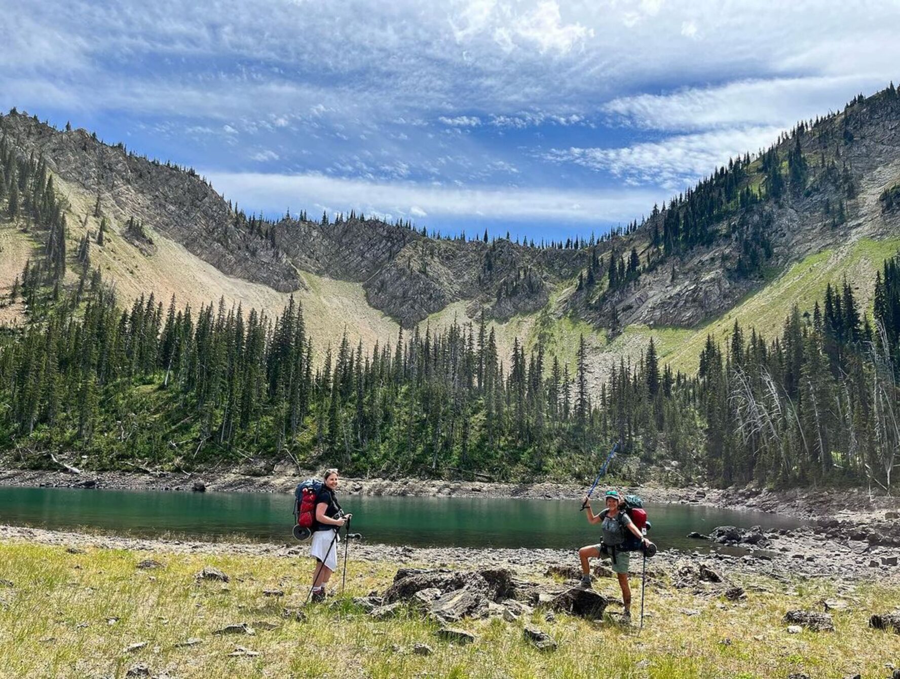 Two hikers enjoying the views of the lake and trees