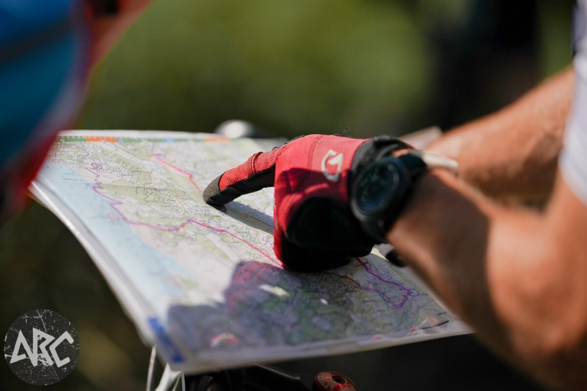 Adventure racers looking and pointing at a map to determine the best strategy