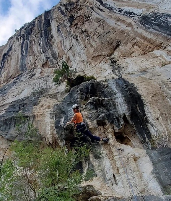 A climber sending a route on a scenic crag in El Potrero Chico.