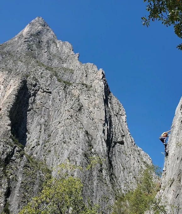 A climber multi-pitching in front of an impressive vista in El Potrero Chico.