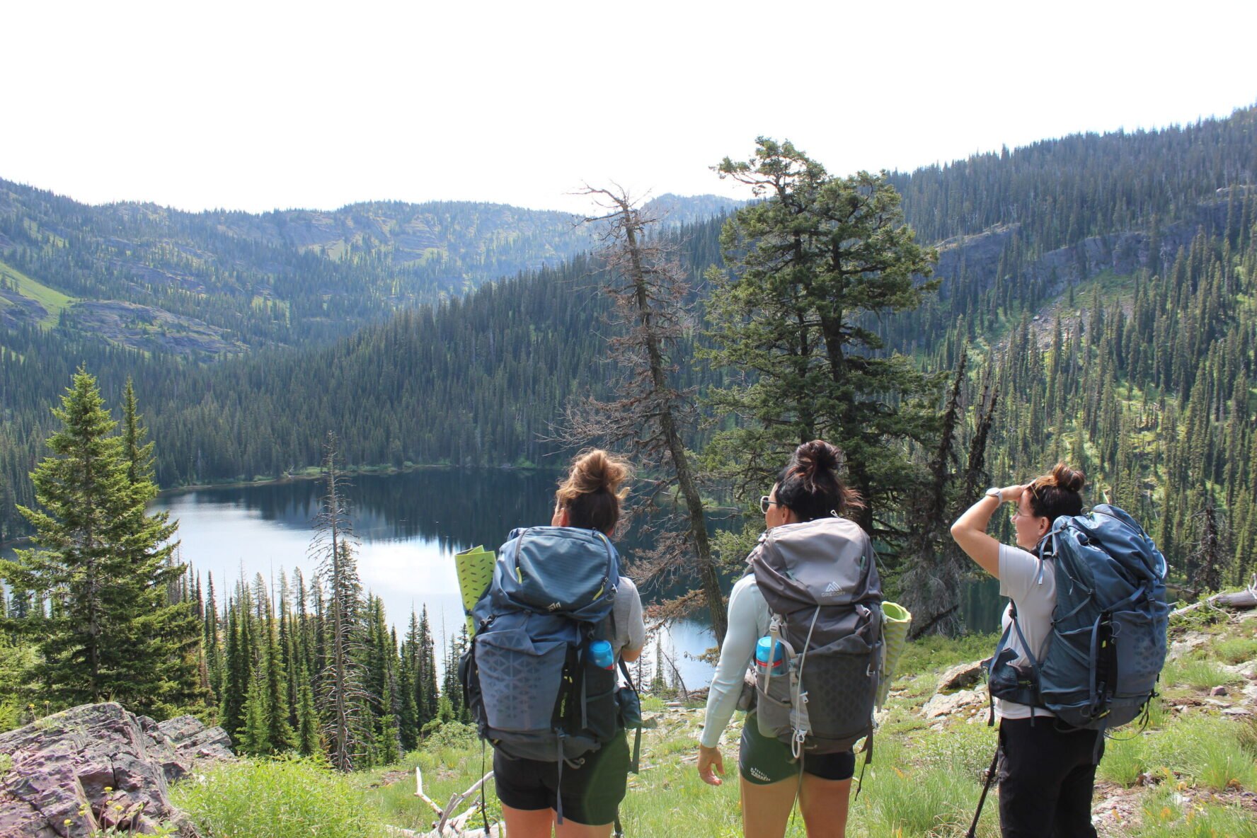 Three backpackers enjoying lake views in Whitefish, Montana