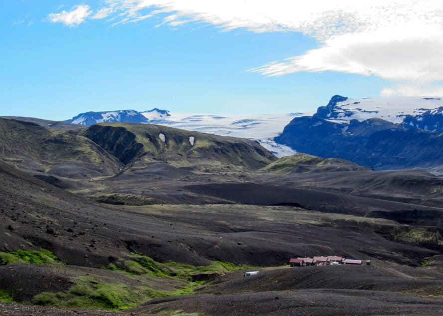 View of mountain huts along the Laugavegur trail surrounded by volcanic ashes and glaciers. 