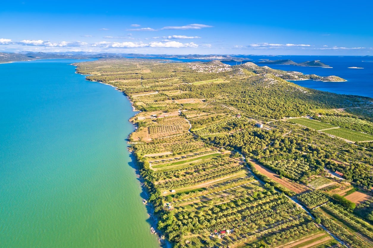 Colorful fields surrounded by the blue and green Vrana Lake