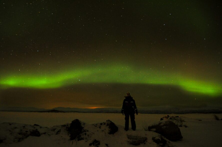 A hiker admiring the Northern Lights in Iceland