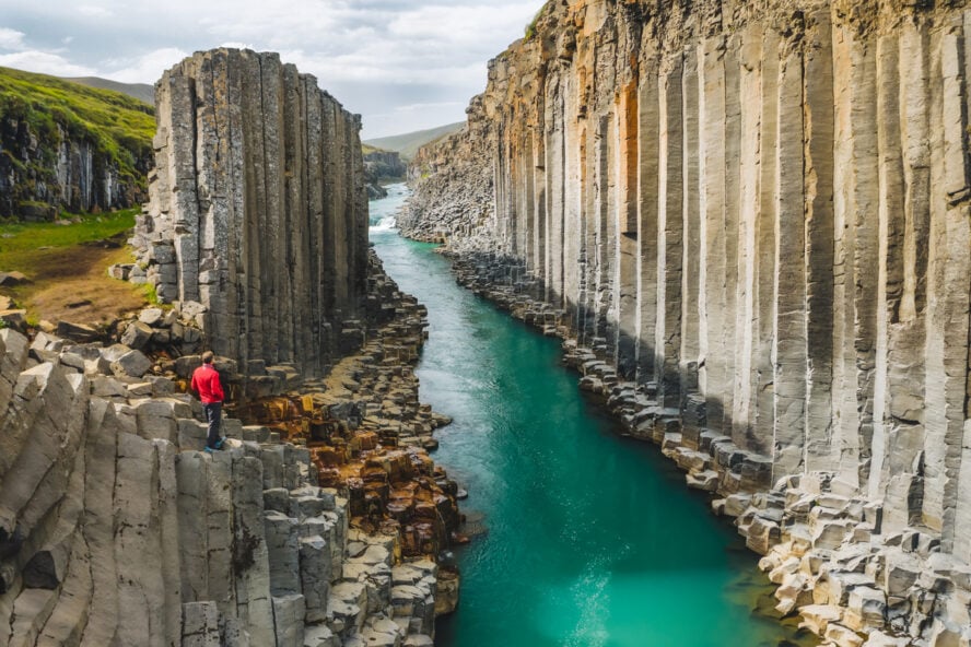 Hiker admiring the basalt columns in Iceland’s Studlagil Canyon