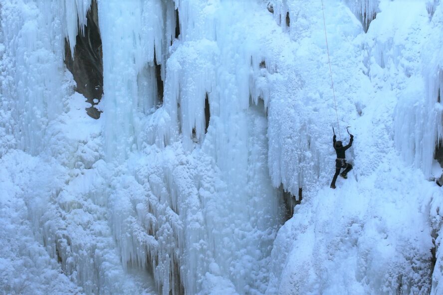 An ice climber facing a waterfall in Ouray, Colorado