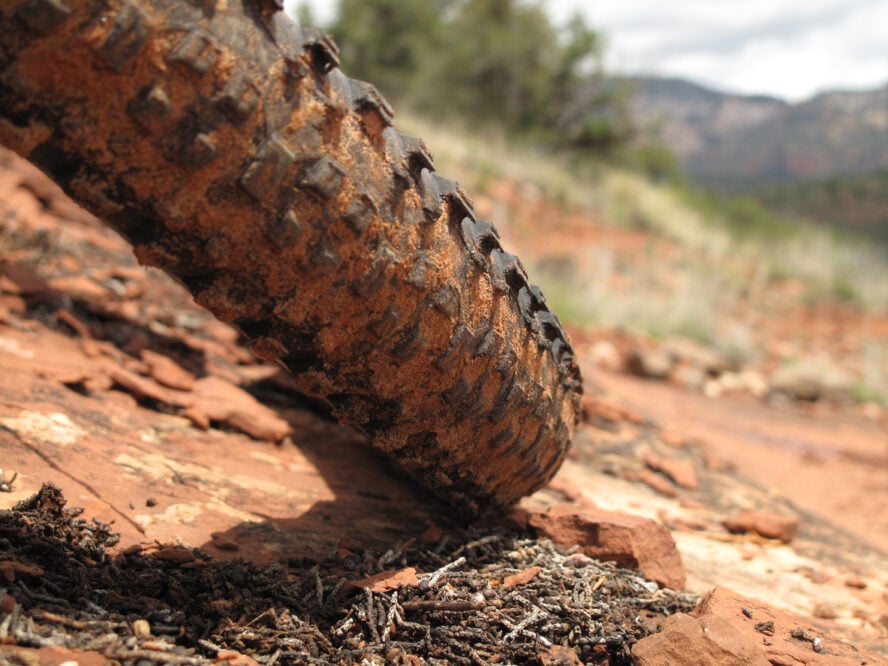 Close-up of a bike tire on a red dirt trail