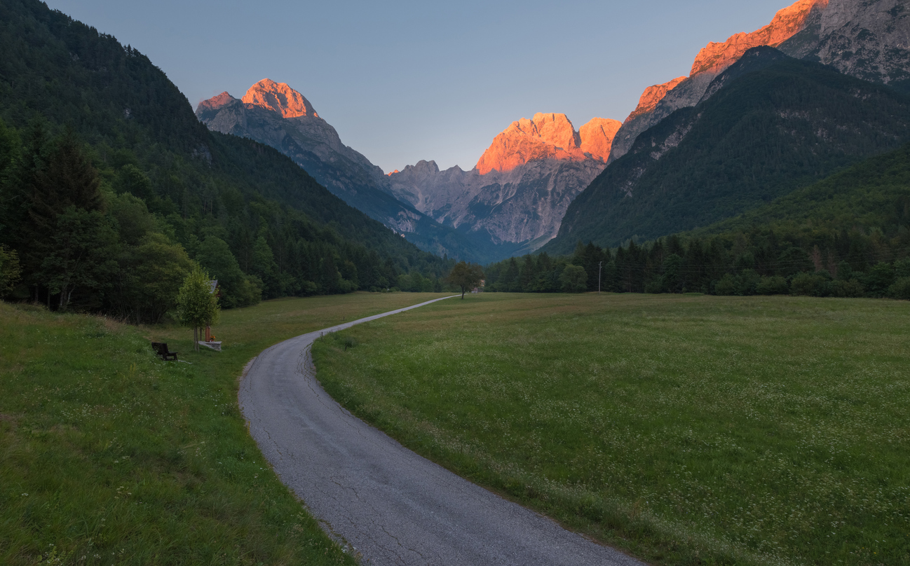 A path cutting across an Alpine Valley in Slovenia during golden hour.
