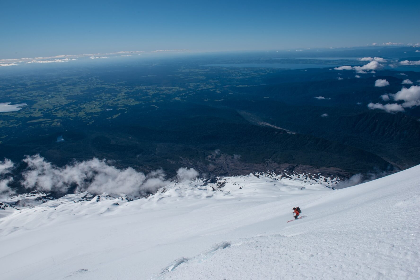A skier on a slope with a panorama of Chile’s flatlands, Patagonia.