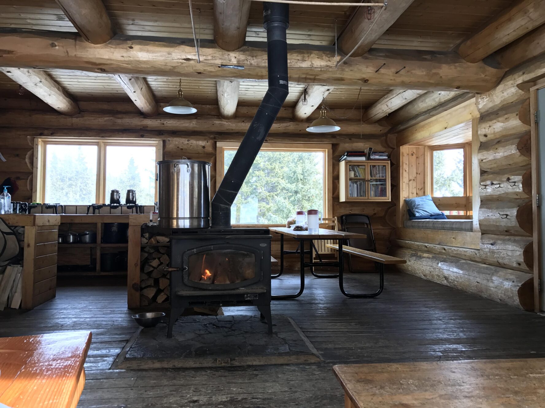 Cozy interior of the hut with a wood-burning fireplace in the center