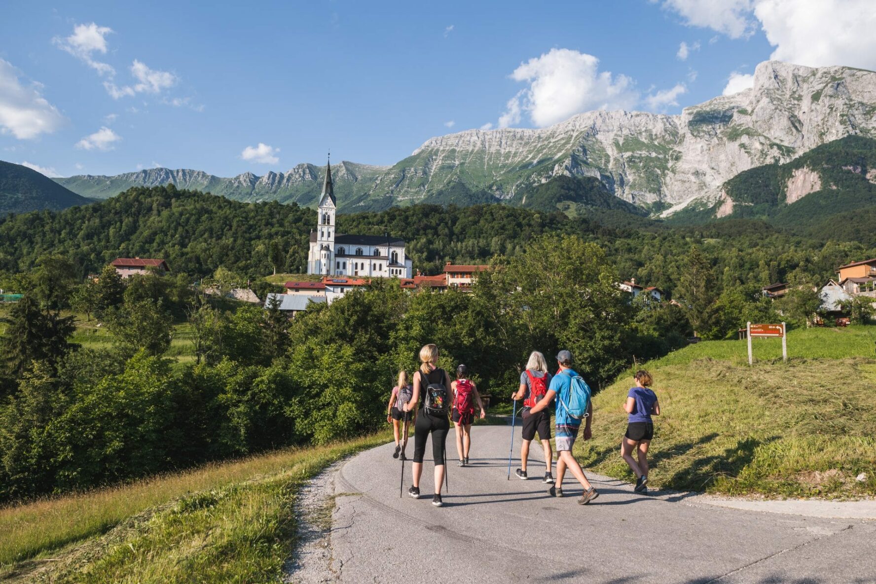 A group of hikers near the town of Kobarik beneath the Krn mountain range.