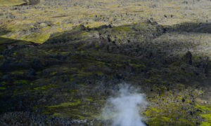 A steaming vent of the Laugahraun lava field, with moss and greenery surprisingly surrounding it.