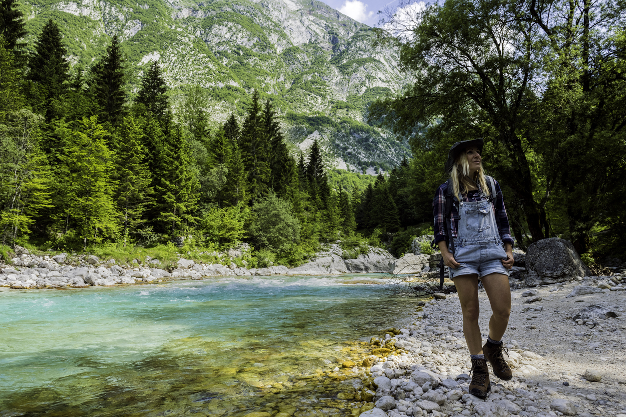 A hiker walking along the banks of the famous Soča river in the Julian Alps.