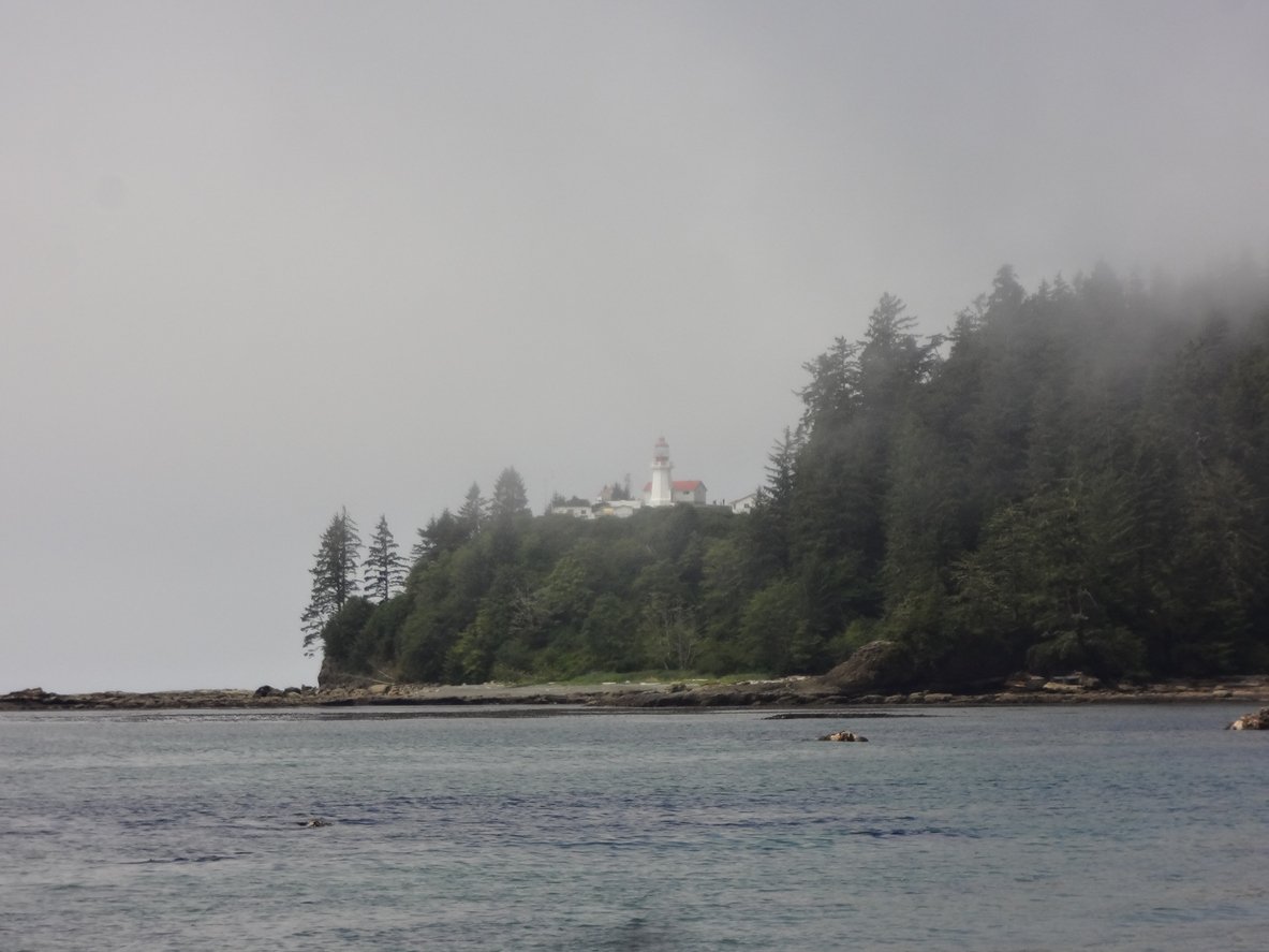 Coastal view of the mist-covered Carmanah lighthouse along the West Coast Trail.