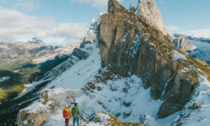 Pair of hikers standing on a viewpoint on Seceda in the Dolomites