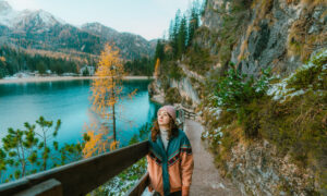 Lone female hiker walking around Lago di Braies in the Dolomites