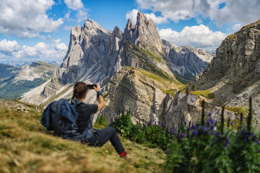 Female hiker standing on top of Seceda in the Dolomites