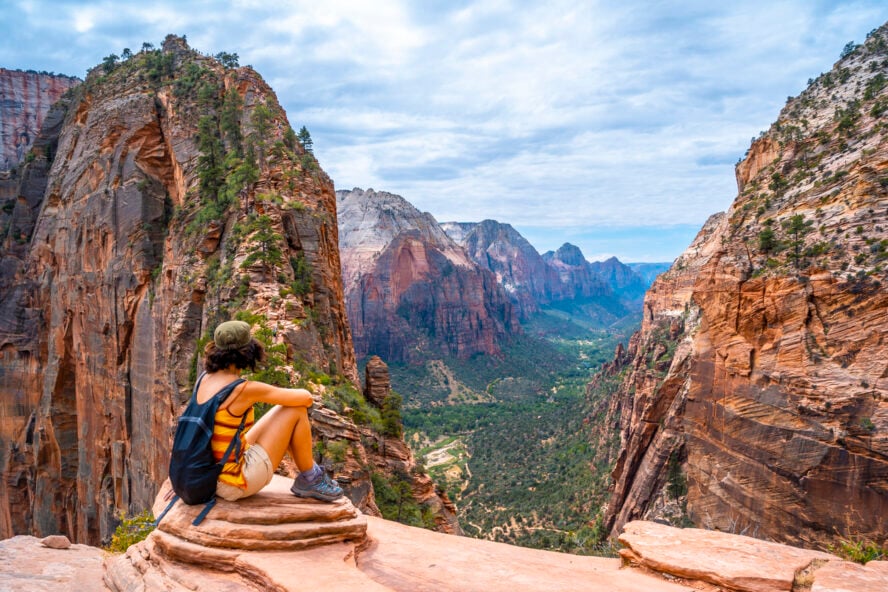 Young woman gazing down into Zion Canyon from Scout Lookout