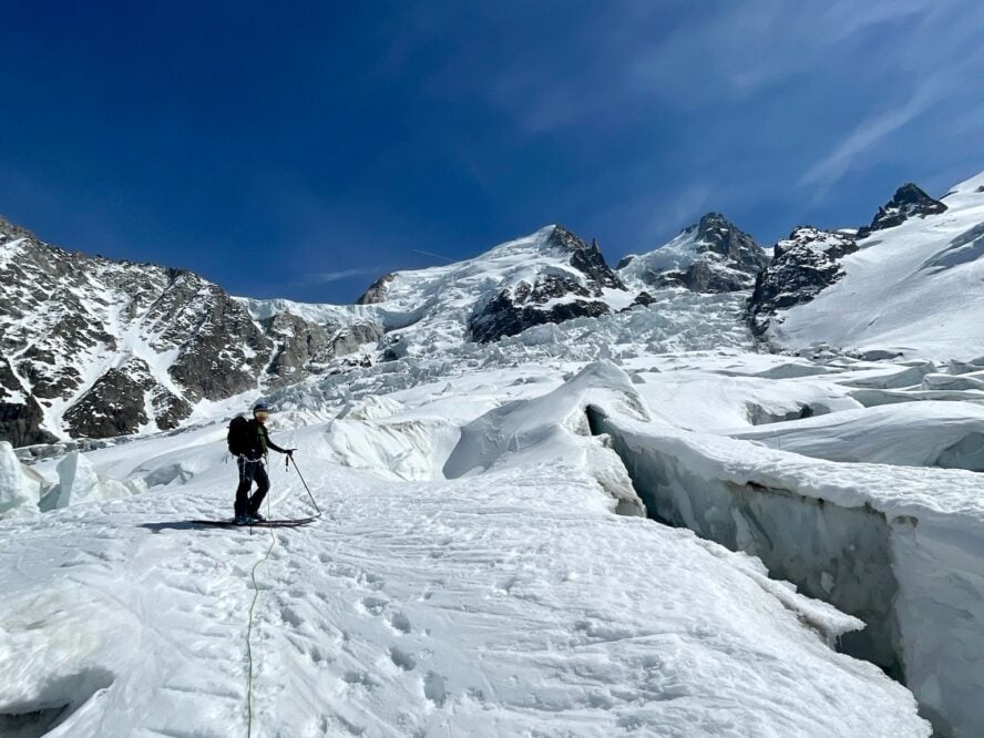 Ski mountaineer roped up and navigating glaciated terrain.