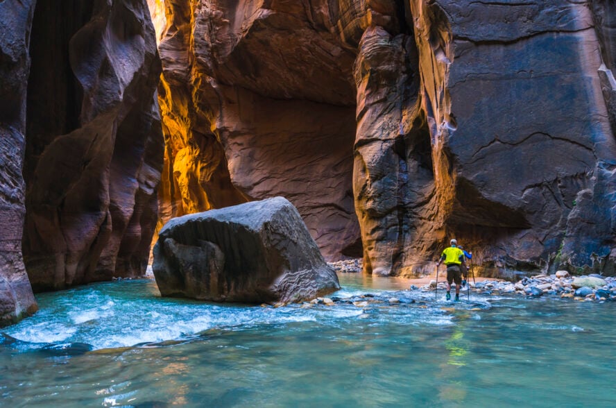 Zion hiker wading through the water in the Narrows