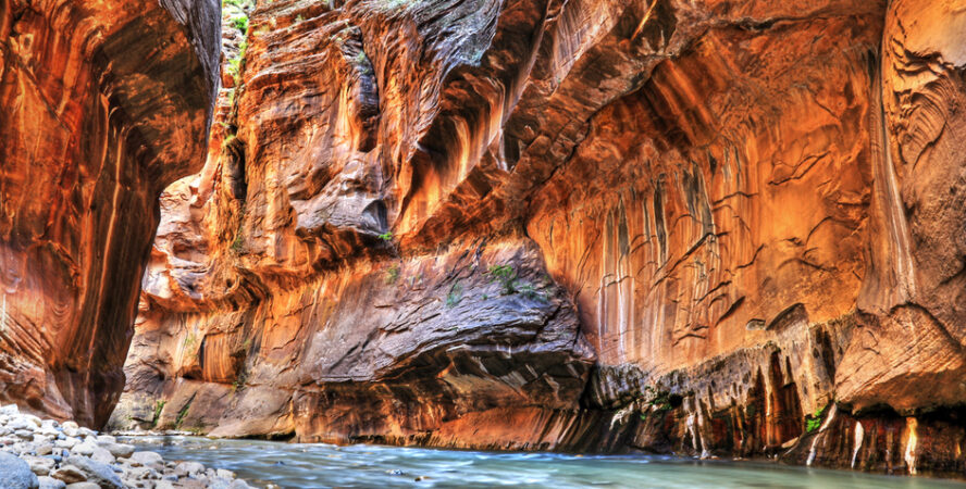 Orange cliffs of Zion Canyon coated with black desert varnish