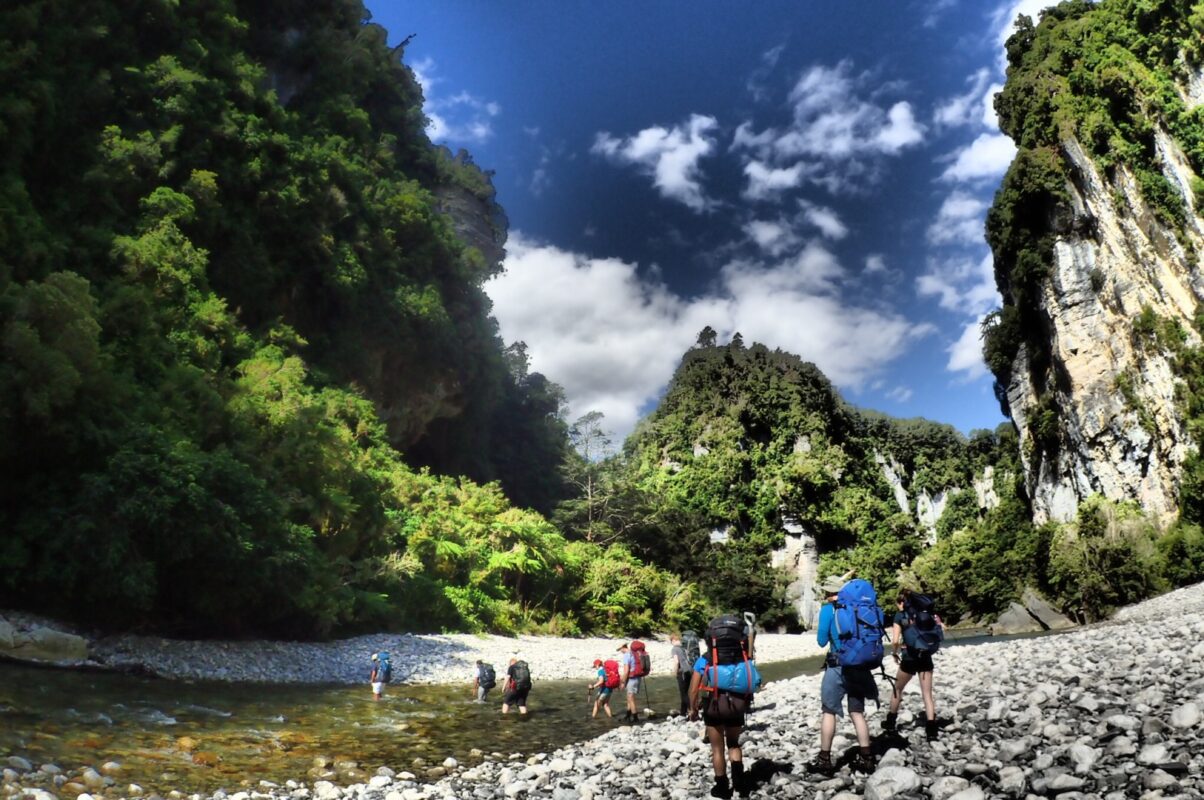 Hikers walking under limestone cliffs in Fox River