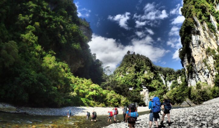 Hikers walking under limestone cliffs in Fox River
