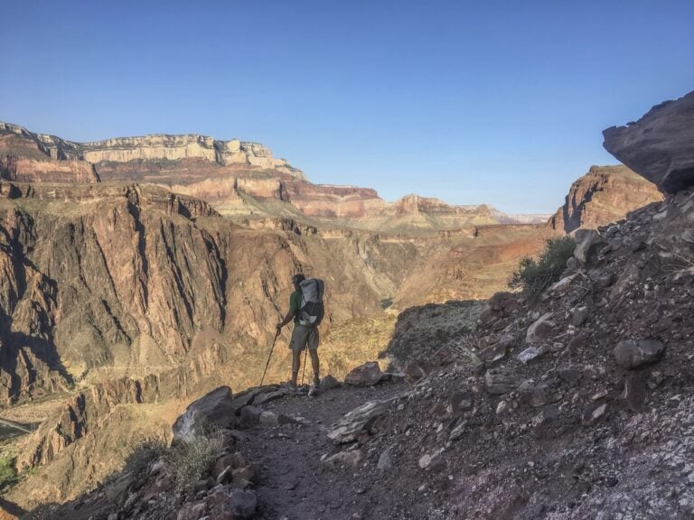 A hiker posing near a drop-off in the Grand Canyon.