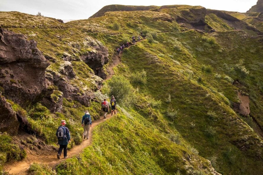 Hikers walking along a trodden path in Thórsmörk.