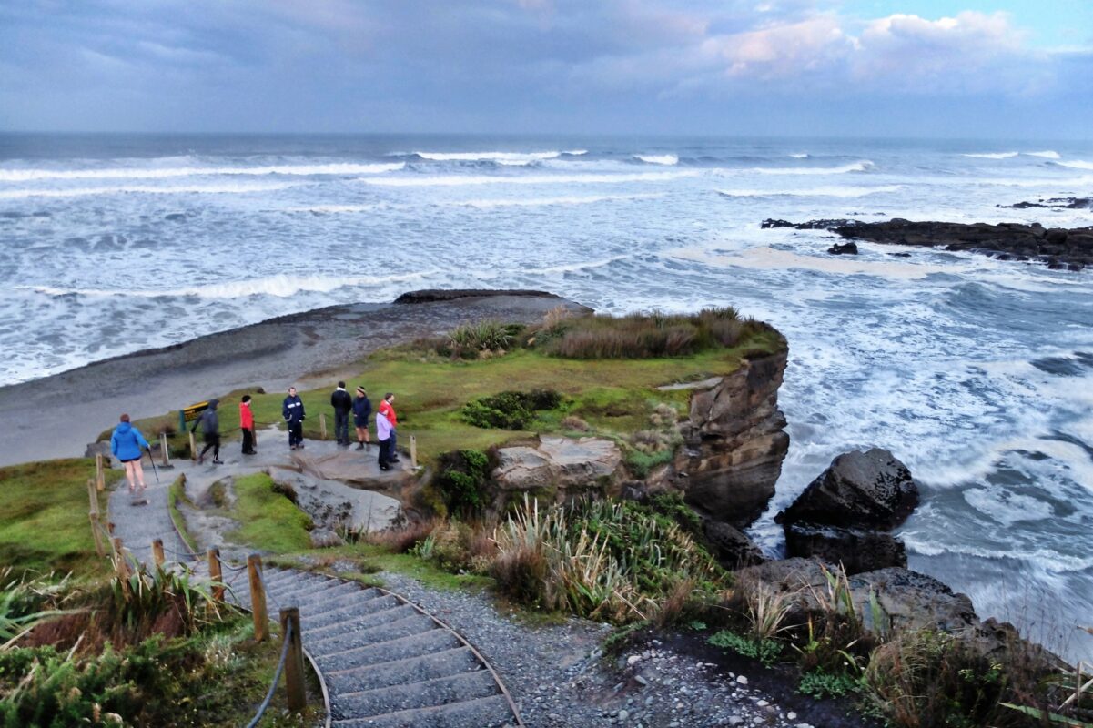 Hikers descending a path near the Tasman sea