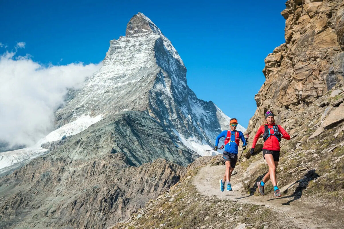 Runners following a trail with views of the Matterhorn in the background.