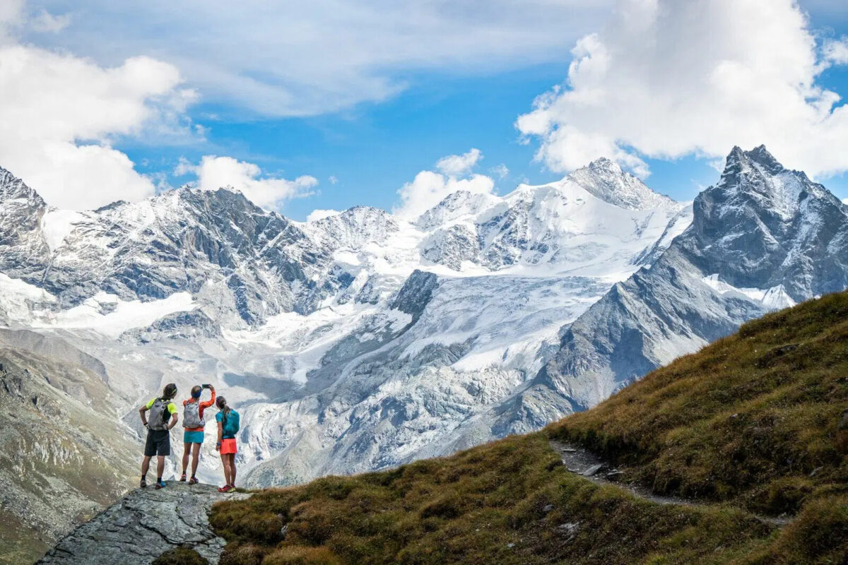 Runners stopping to take a photo of a vista right above Zinal, Switzerland. 