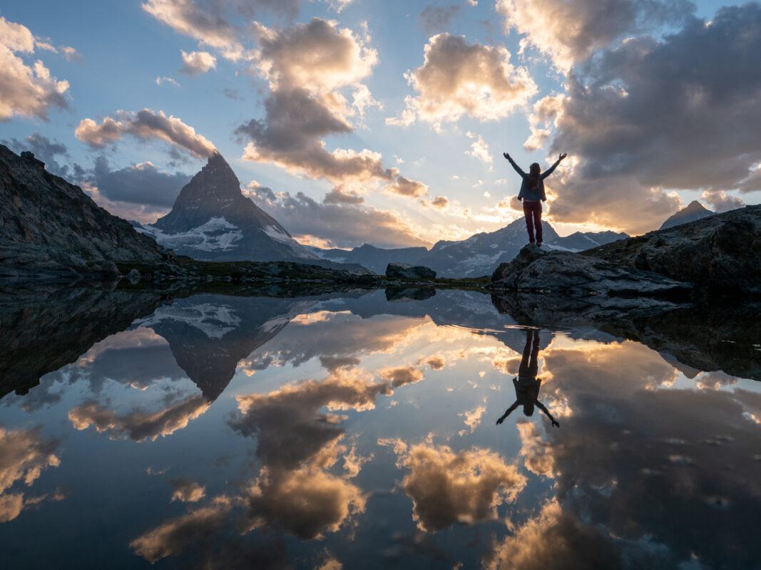 A trail runner posing in front of a sunset in Zermatt, Switzerland. 