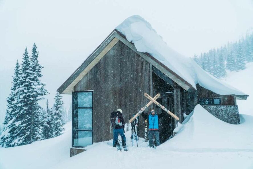 Two skiers outside the Thelma Hut, getting ready for a day in the backcountry. 