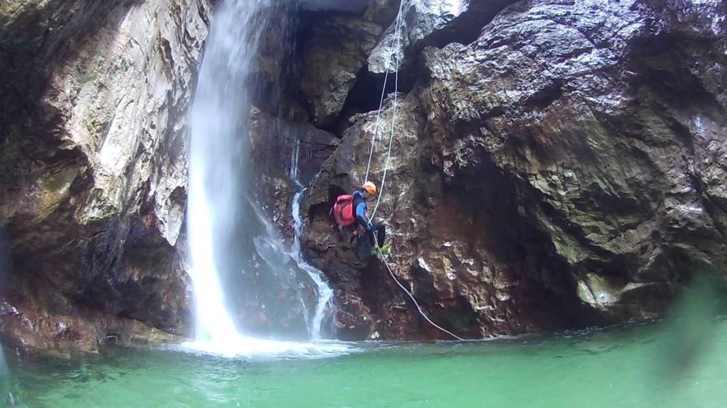 Canyoneer lowering down a waterfall