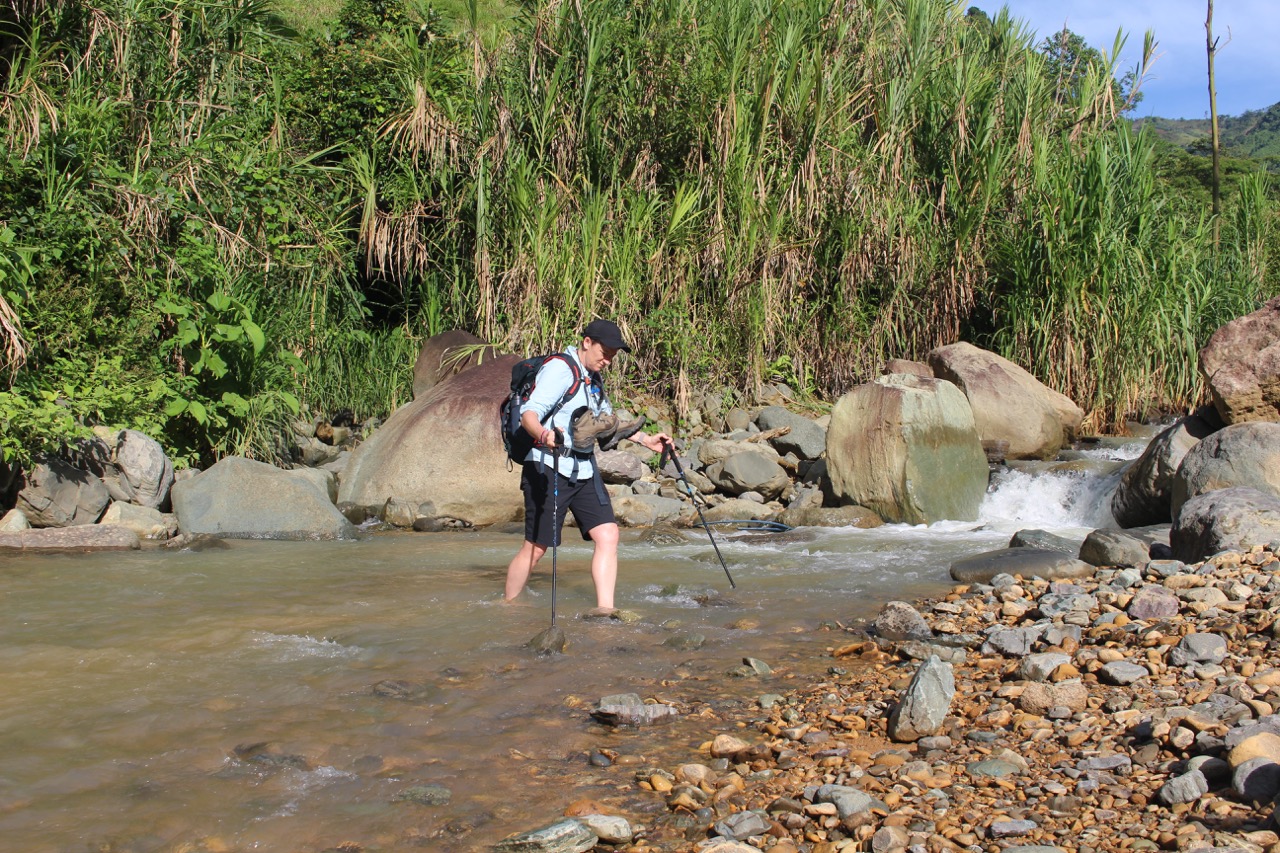 Hiker fording a river in Costa Rica