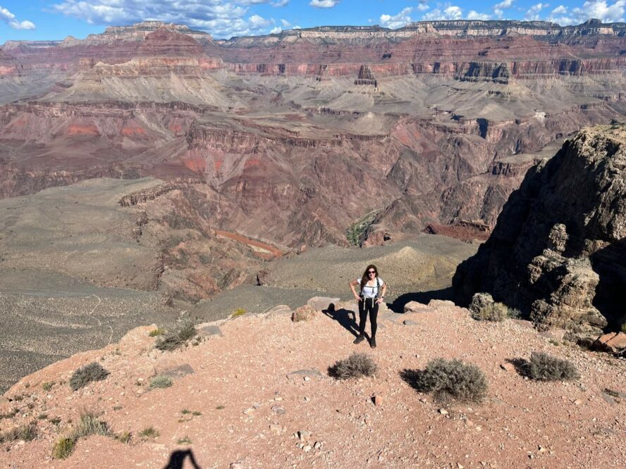  A man standing on a rocky overlook, peering out into the Grand Canyon.