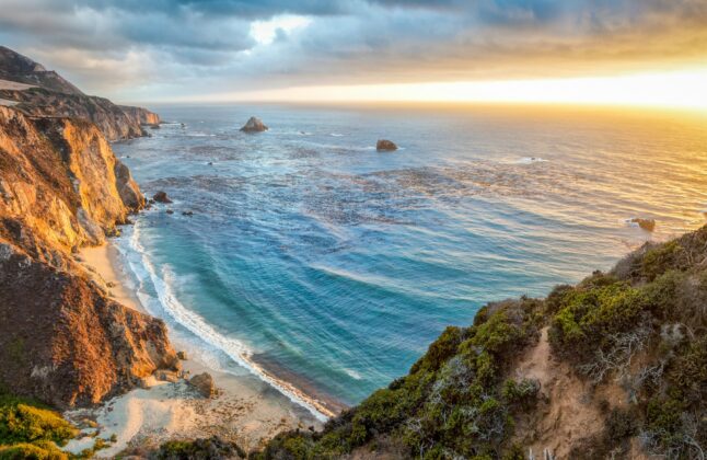 Panorama of Big Sur looking out onto the Pacific Ocean at sunset.