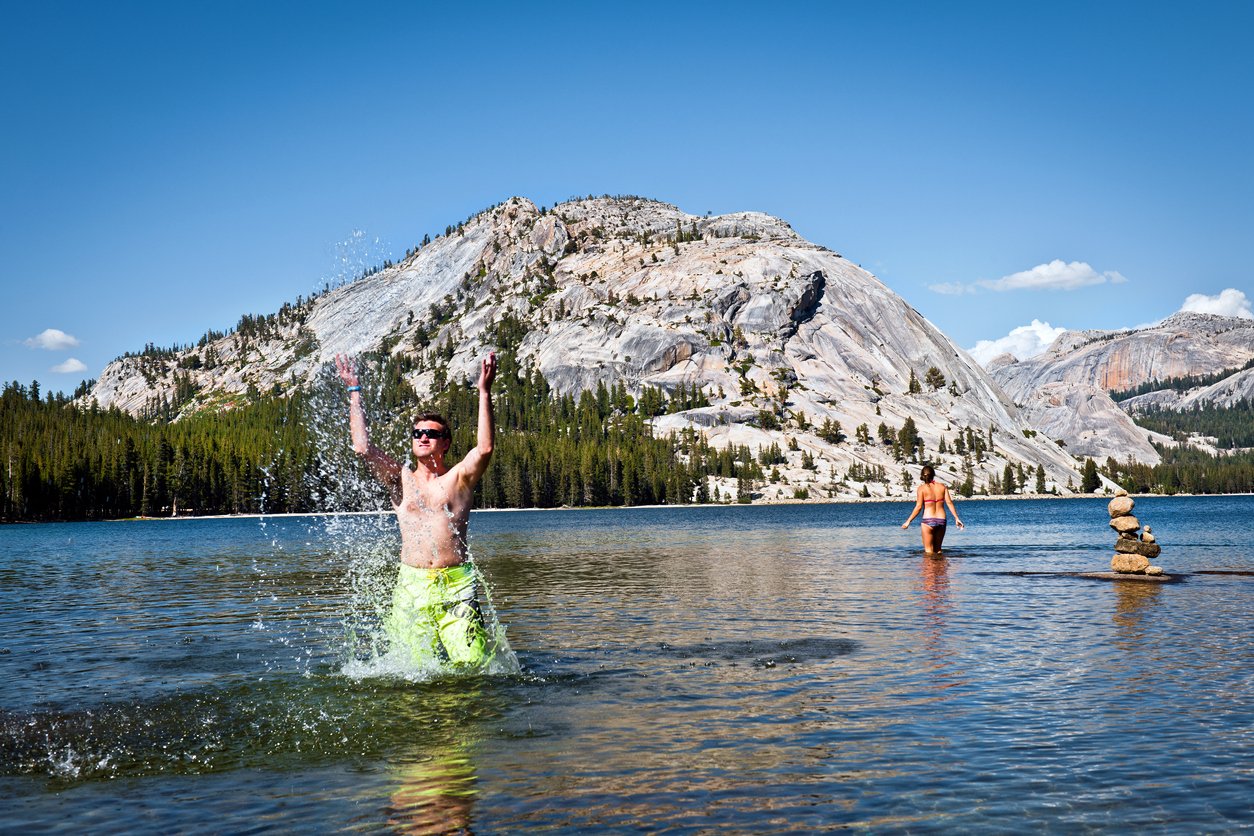 Backpackers getting refreshed and having fun in a crystal-clear lake in Yosemite.