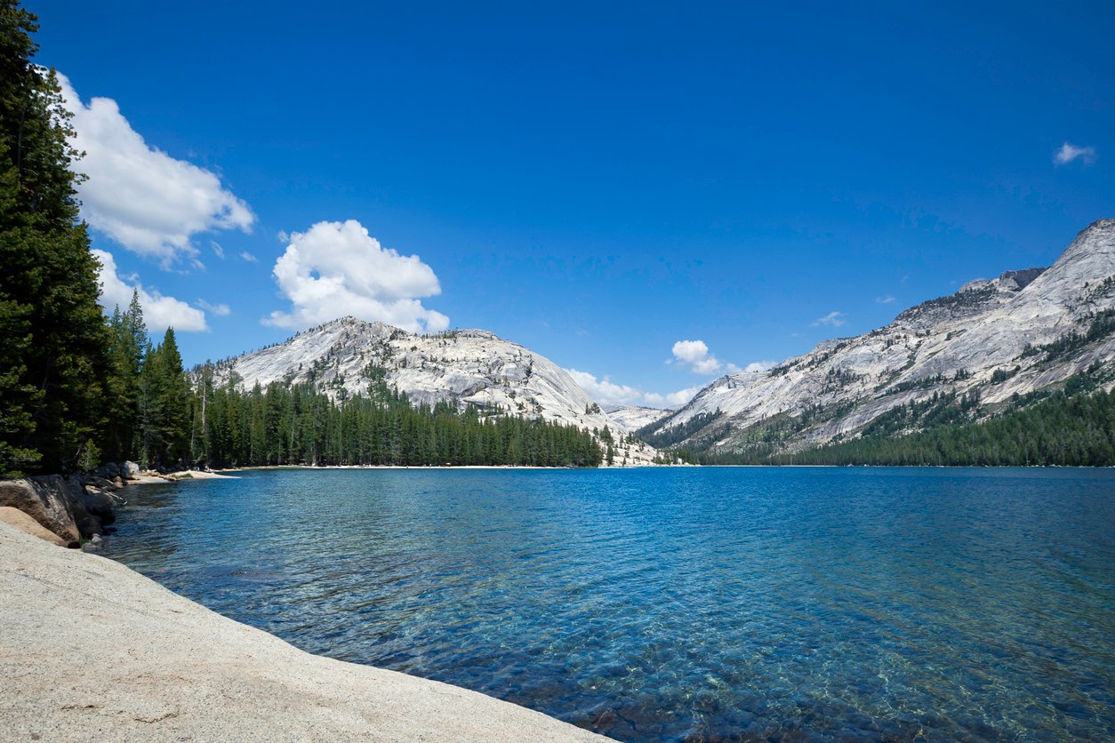 Sapphire Tenaya lake surrounded by peaks and conifers as seen during a backpacking tour in the Yosemite National Park.