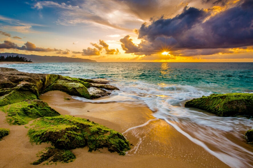 Sun setting over a sandy beach in Hawaii