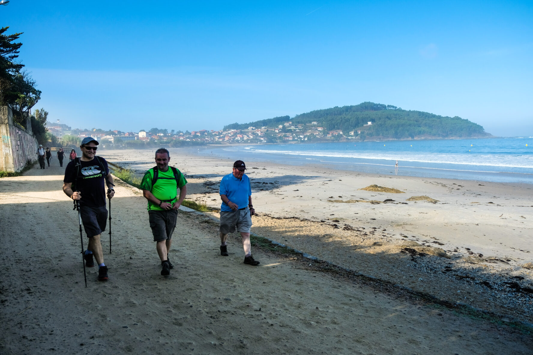 Three hikers walking on the beach